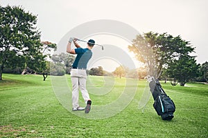 Golf, stroke and training with a sports man swinging a club on a field or course for recreation and fun. Golfing, grass