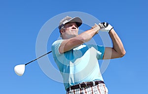 Golf, swing and elderly man with driver outdoor for training, hobby and sports on blue sky background. Club, swinging