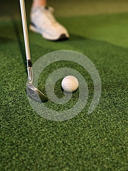 Golf swing practice on artificial turf with a white ball