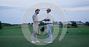 Golf team fight together at green course. Two men argue at country club field