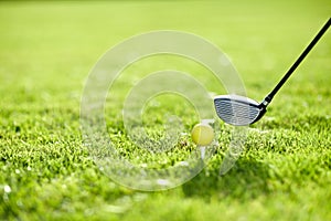 Golf, tee and ball with club on field by ready with swing to hit in hole on driving range in closeup. Sports, training