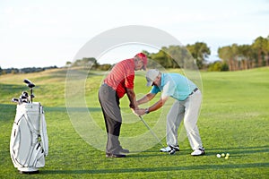 Golf training, help and men with a game on a field for a competition, showing or support. Fitness, exercise and friends