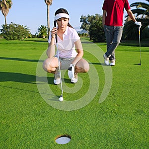 Golf young woman looking and aiming the hole photo