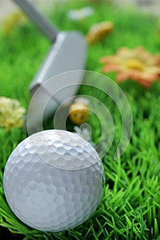 Golfball and club on artificial grass