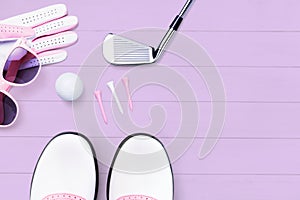 Golf accessories for women on a wooden surface in purple