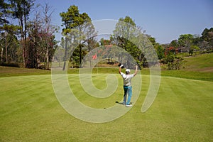 Golfer action happiness winner with long putting golf ball straight to hole