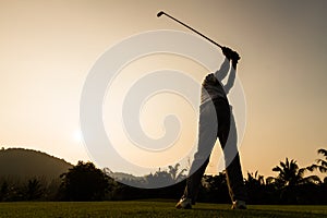 Golfer action while sunset