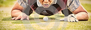 Golfer blowing ball in the hole