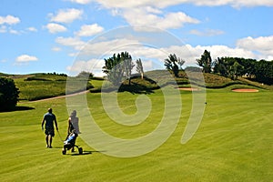 Golfer and caddy girl walking