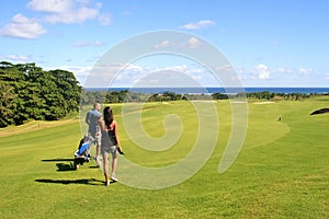 Golfer and caddy girl walking photo