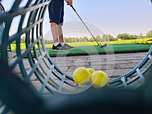 Golfer child on practice mat during golf lesson