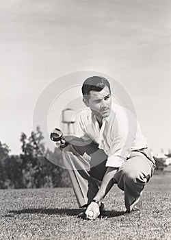 Golfer crouching on golf course