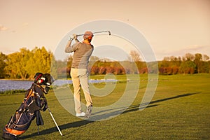 Golfer on fairway in evening.