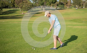 golfer full length in cap with golf club, summer