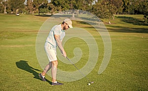 golfer full length in cap with golf club, summer