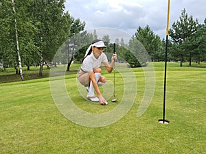 Golfer on golf course putts up on green course photo