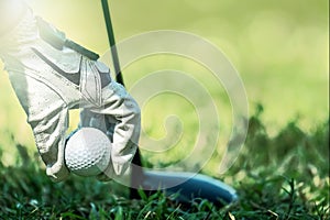 Golfer hand with glove picking up golf ball