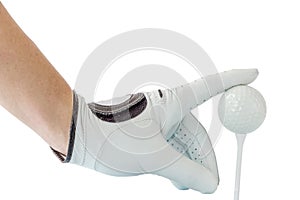 Golfer hand in white glove action with golf ball on tee with white background.