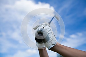 Golfer hands in gloves holding iron