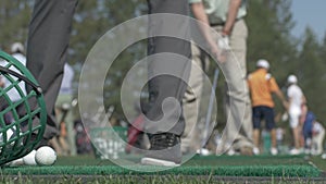 Golfer Hitting Ball with Club on Beautiful Golf Course. Golfer hits an fairway shot towards the club house. Man hitting