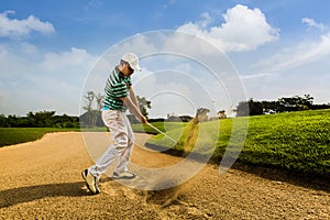 Golfer hitting the ball on the sand. Speeds Cause blurred