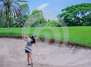 Golfer hitting the ball on the sand. Speeds Cause blurred by movement