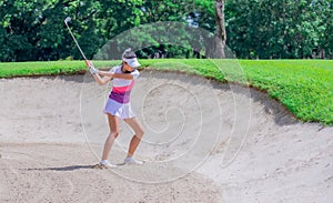 Golfer hitting the ball on the sand. Speeds Cause blurred by movement