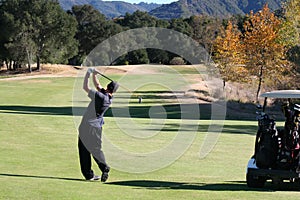 Golfer hitting down fairway photo