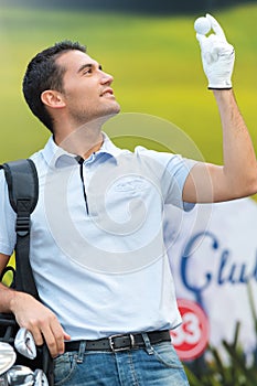 Golfer holding ball and golf club