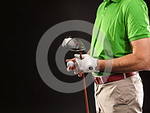 Golfer holding golf ball and a drive on black background