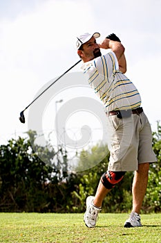 Golfer with knee brace.