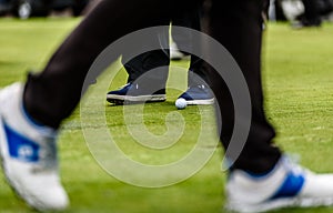 Golfer legs at golf tournament practice swing with golf club