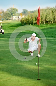 Golfer lining up a putt.