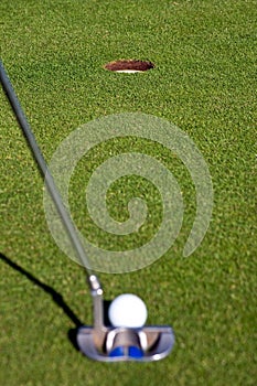 Golfer lining up a short putt - focus on the hole