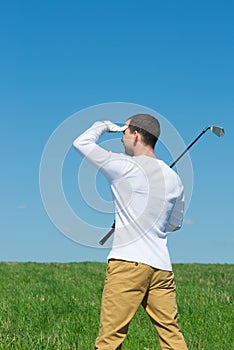 Golfer looking away defensively from the sun hand