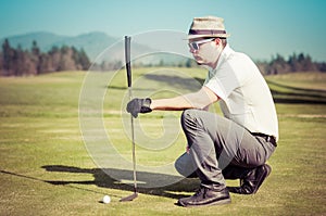 Golfer looking golf shot with club