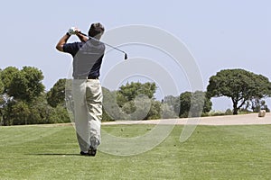 Golfer making fairway shot photo