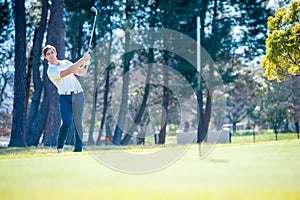 Golfer playing a chip shot onto the green