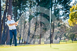 Golfer playing a chip shot onto the green