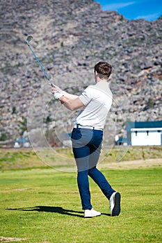 Golfer playing a chip shot onto the green