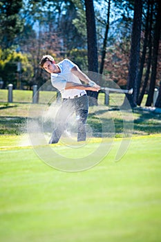 Golfer playing a chip shot onto the green