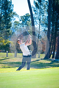 Golfer playing a chip shot onto the green