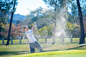 Golfer playing a chip shot onto the green