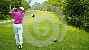 Golfer playing golf in the evening golf course, on sun set evening time