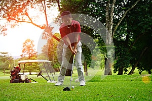 Golfer playing golf beside the golfcar in beautiful golf course in the evening golf course with sunshine