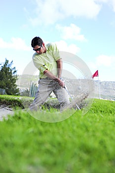 Golfer playing out of a sand trap