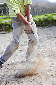 Golfer playing out of a sand trap