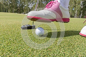 Golfer preparing for a putt on the green during golf course.