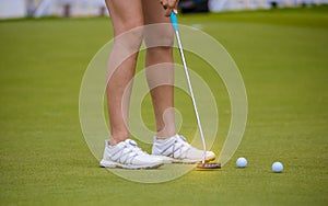 Golfer is pushing golf ball by golf club from tee boxes at golf course in competition game