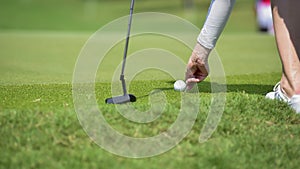 Golfer is pushing golf ball by golf club from tee boxes at golf course in competition game